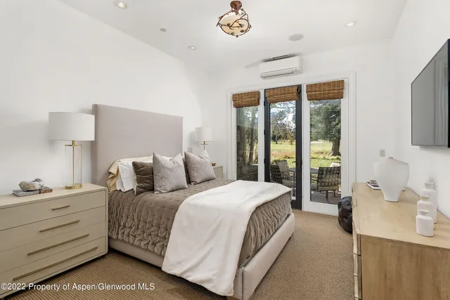 a bedroom with a bed and a flat tv screen on dresser