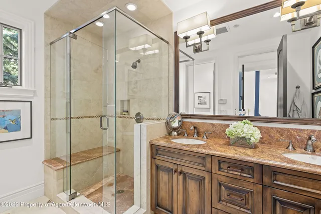 a bathroom with a granite countertop shower sink and mirror