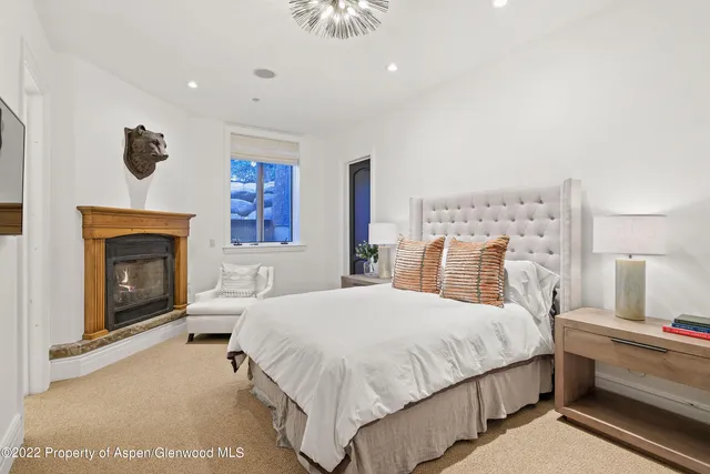 a bedroom with a large bed and a fireplace