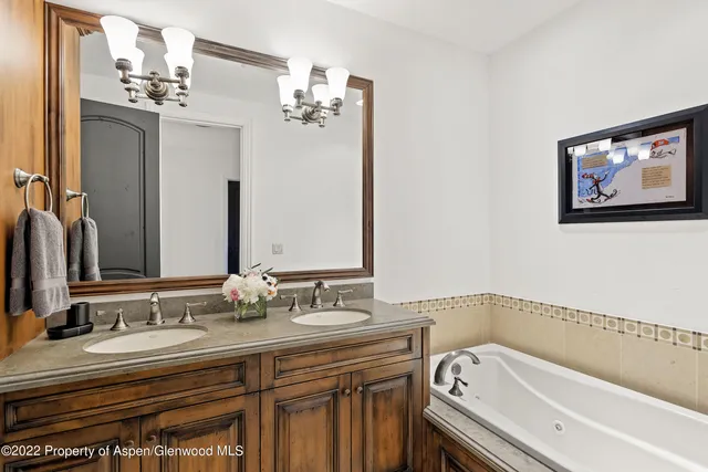 a bathroom with a tub sink and mirror