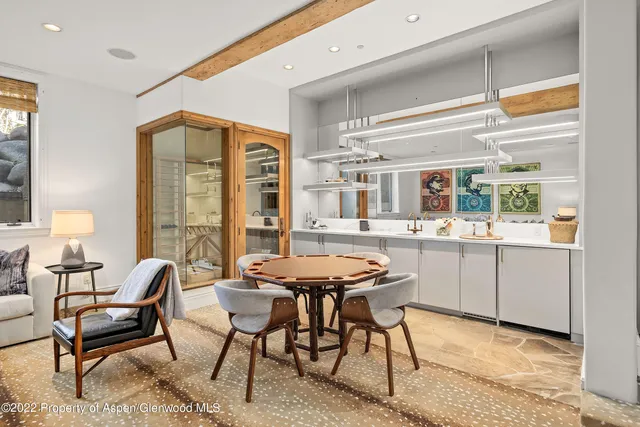 a kitchen with a table chairs a sink dishwasher window and cabinets