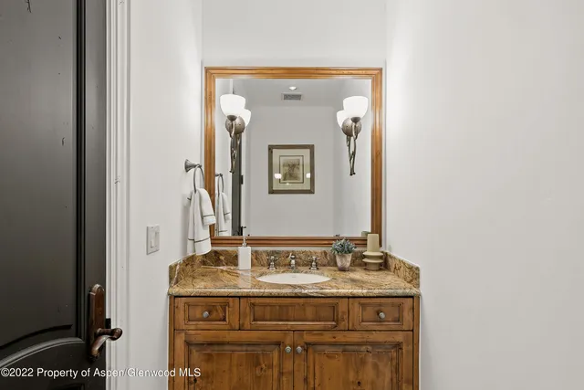 a bathroom with a granite countertop sink a mirror and a vanity