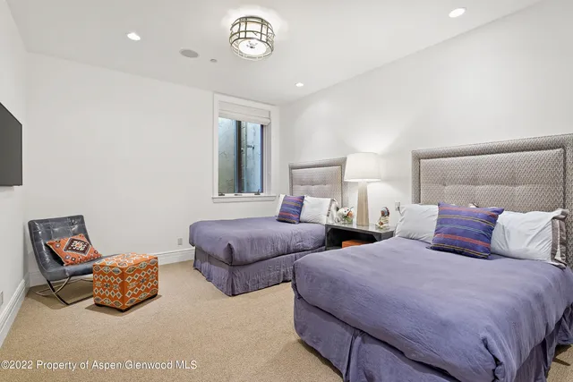 a bedroom with two beds and a lamp