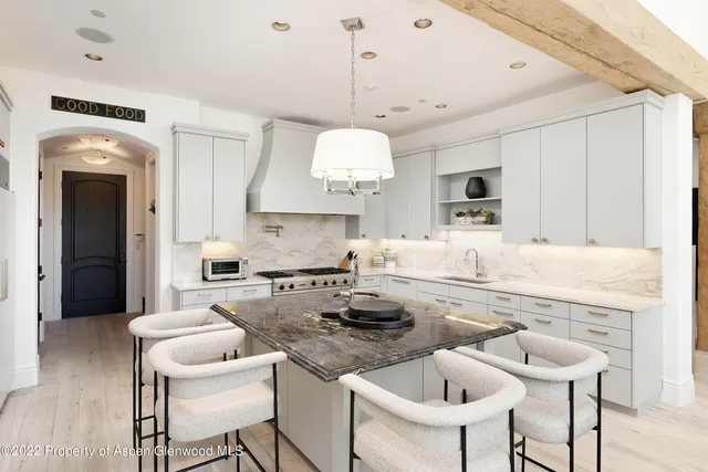 a kitchen with kitchen island granite countertop a sink and a stove