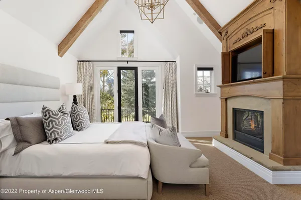 a spacious bedroom with a balcony a bed and a fireplace