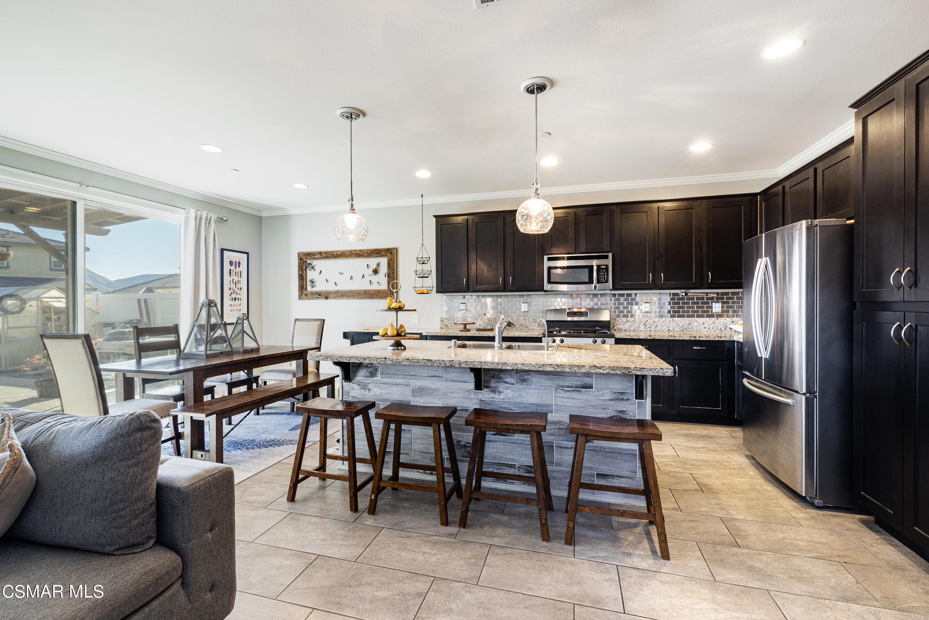 396 Edgewood Drive Fillmore, CA 93015 - Photo 7 of 29 a kitchen with stainless steel appliances kitchen island granite countertop a refrigerator a stove a sink a dining table and chairs