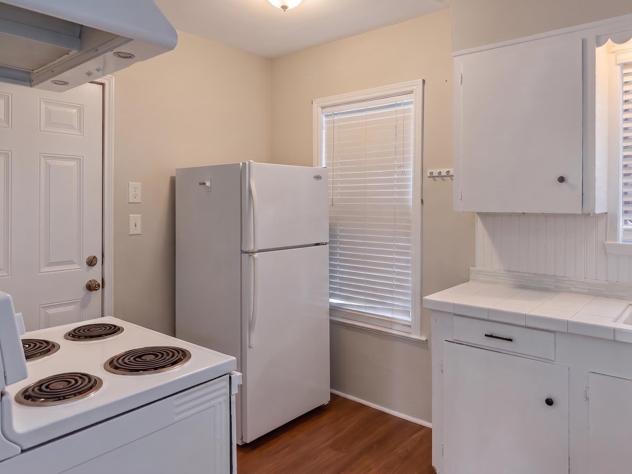 2313 Avenue L Rosenberg, TX 77471 - Photo 13 of 31 Kitchen with white appliances, ample cabinet storage, and convenient access to the exterior.