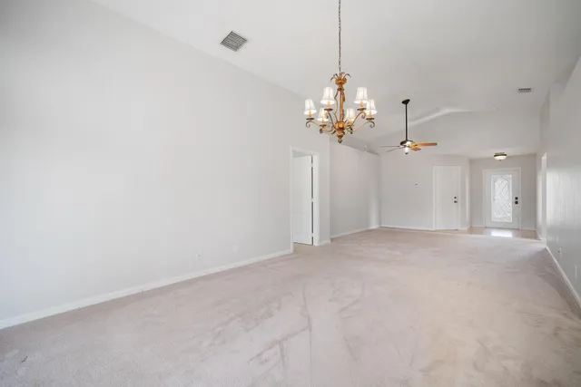 a view of a big room with chandelier fan and windows
