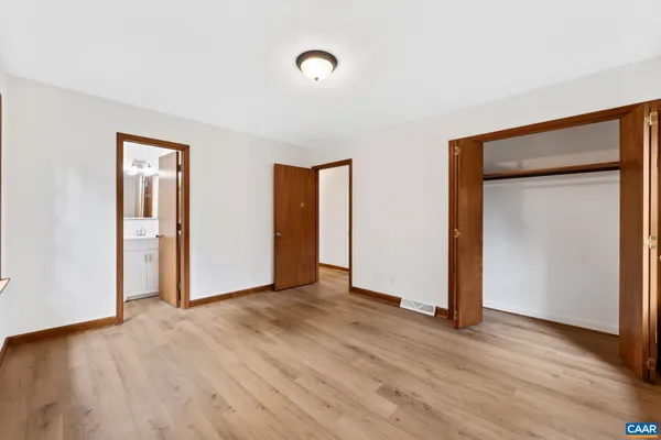 an empty room with wooden floor and closet