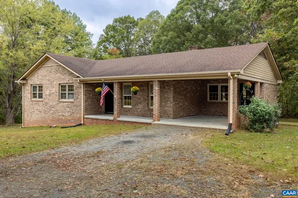 a view of a house with a yard and large tree