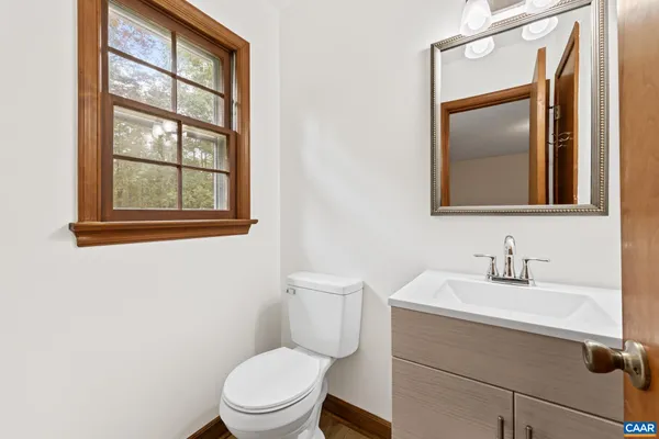 a bathroom with a toilet a sink and mirror