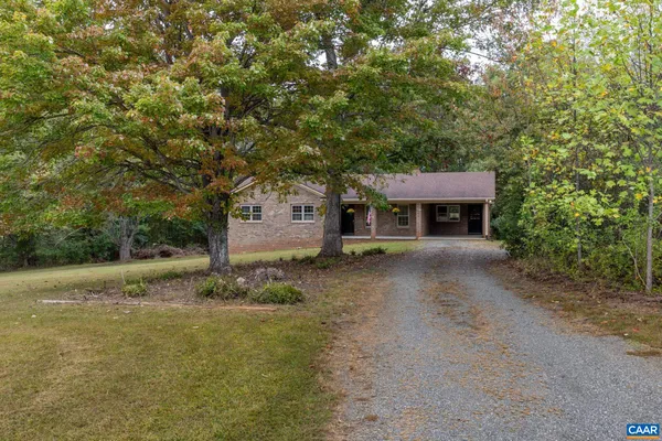 a view of a house with a yard and large tree