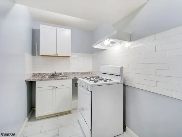a kitchen with a stove sink and cabinets