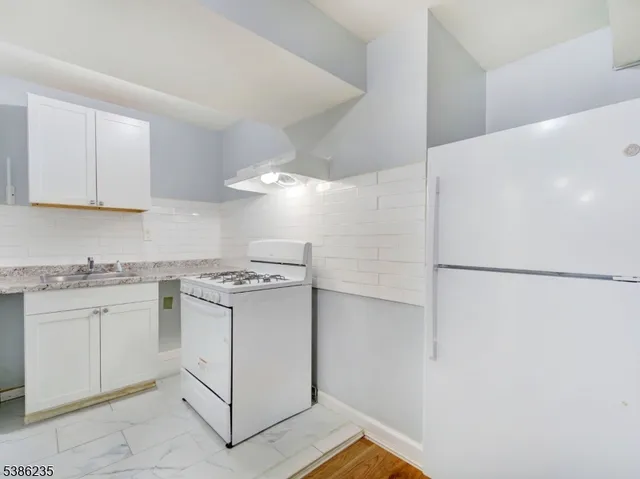 a kitchen with stainless steel appliances granite countertop a refrigerator a stove a sink and a refrigerator