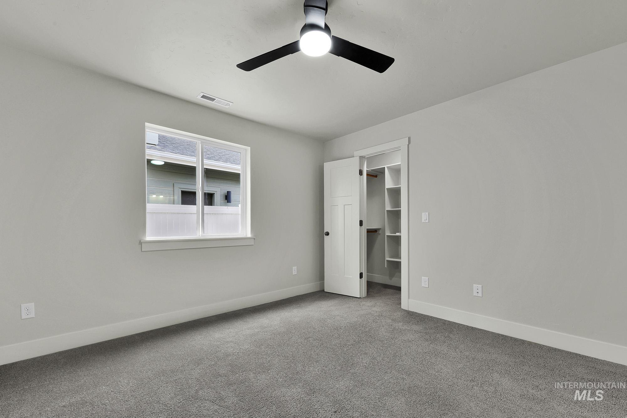 328 Packer Lane Homedale, ID 83628 - Photo 12 of 25 Unfurnished bedroom featuring carpet flooring, a walk in closet, and a ceiling fan