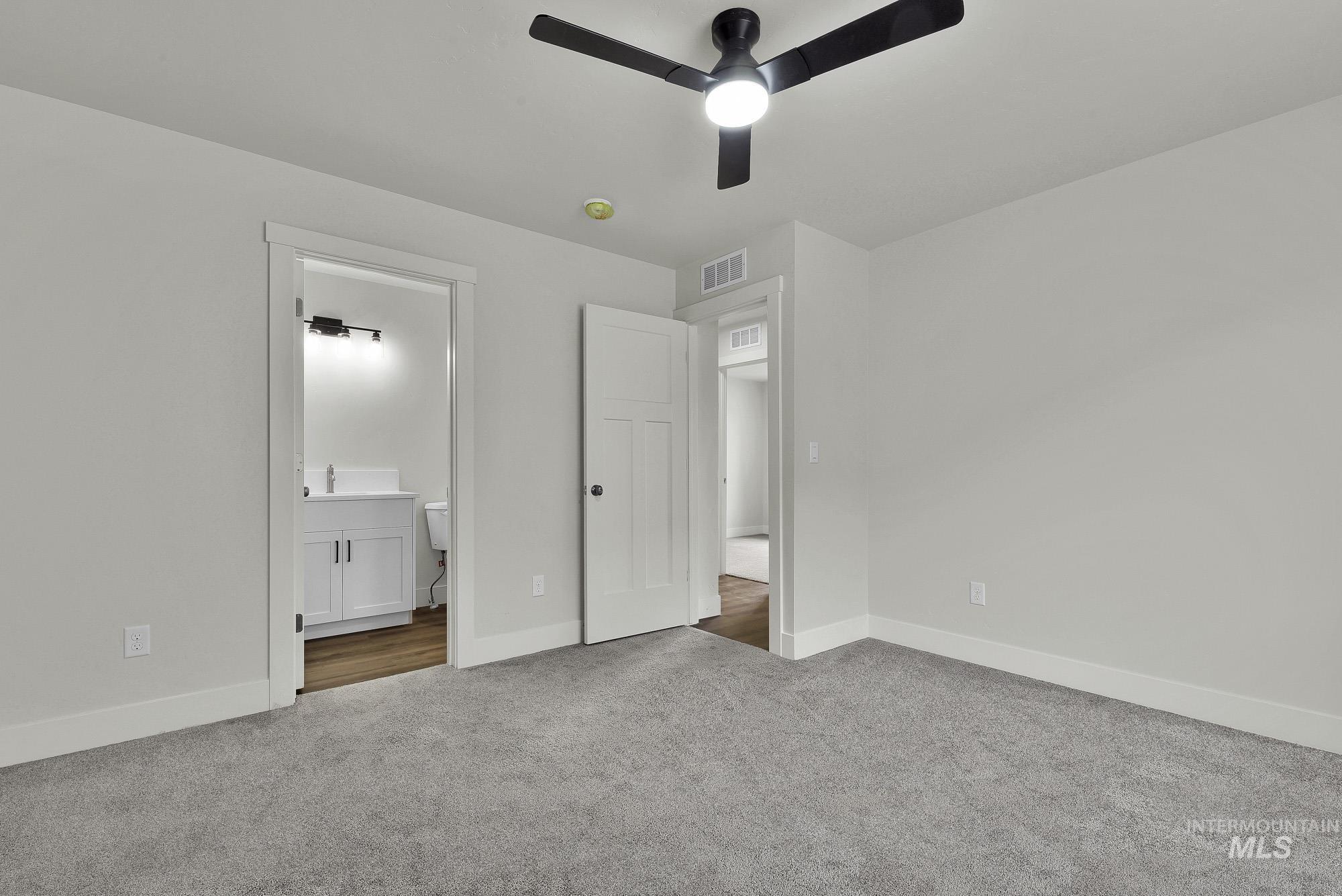 328 Packer Lane Homedale, ID 83628 - Photo 14 of 25 Unfurnished bedroom featuring carpet, ensuite bathroom, and ceiling fan