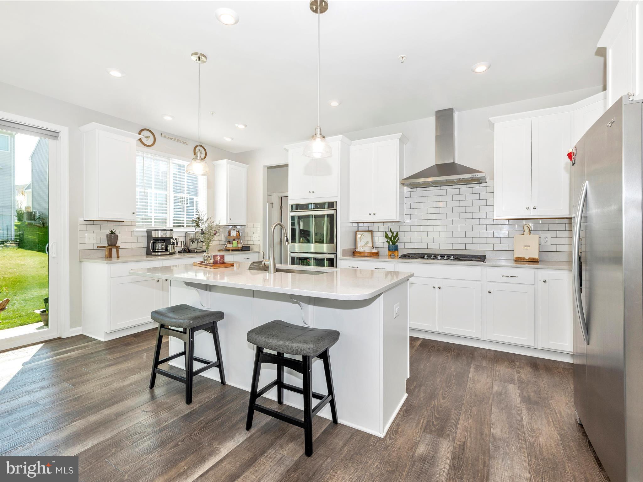 5816 Hawk Ridge Road Frederick, MD 21704 - Photo 16 of 97 a kitchen with stainless steel appliances granite countertop a stove a sink a refrigerator and white cabinets with wooden floor