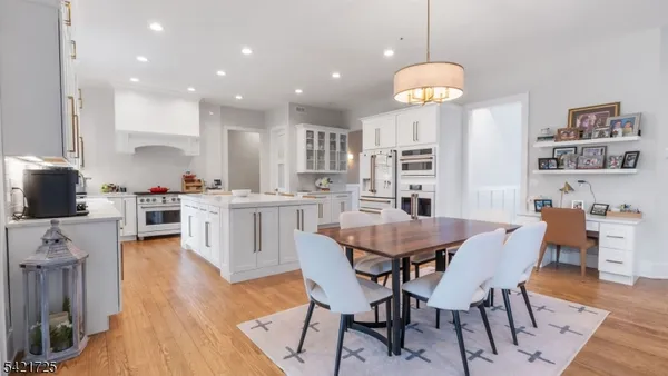 a living room with furniture kitchen view and a wooden floor