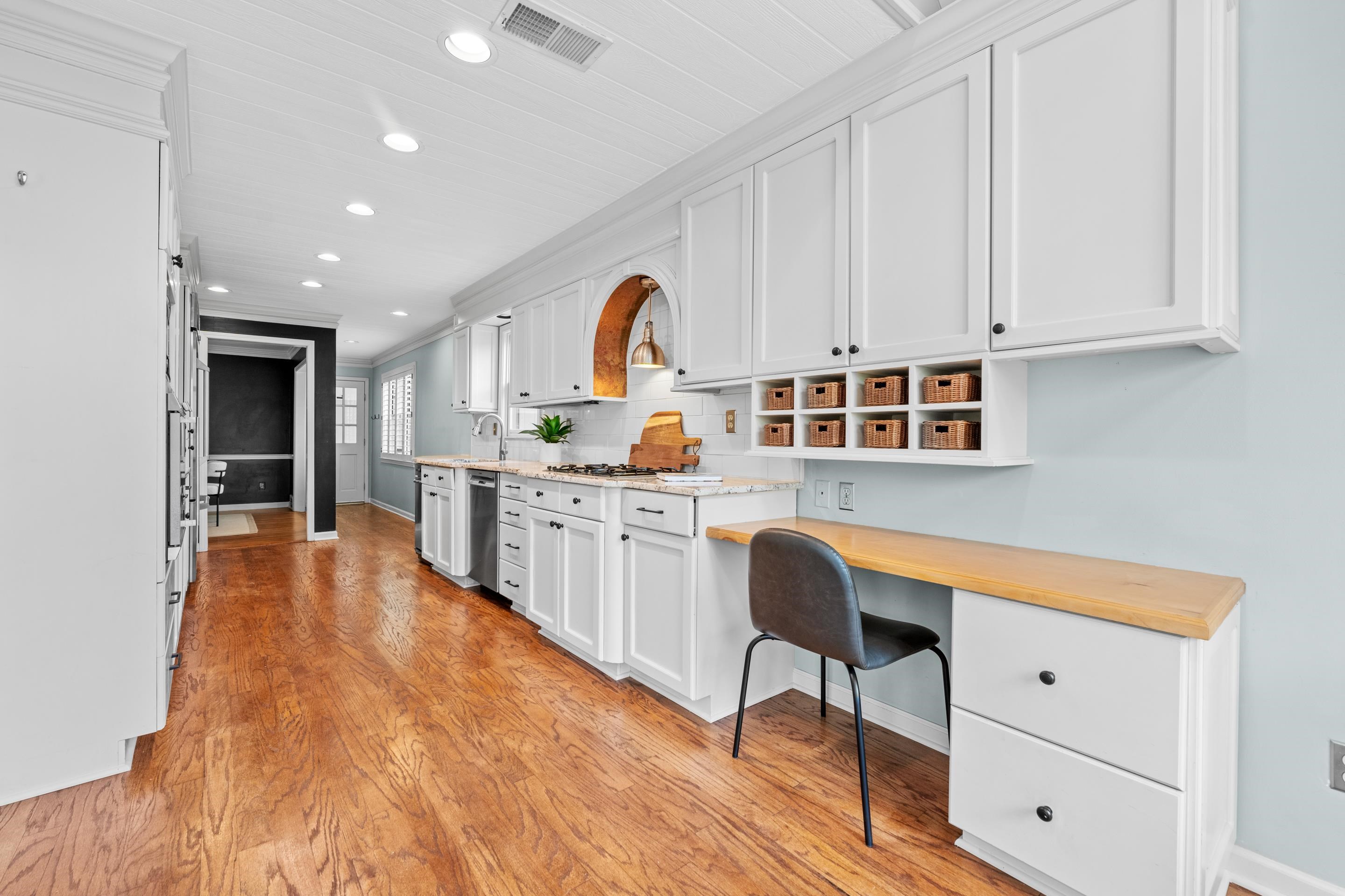179 Ericson Road Memphis, TN 38018 - Photo 7 of 39 a large white kitchen with kitchen island a stove a sink dishwasher and white cabinets with wooden floor