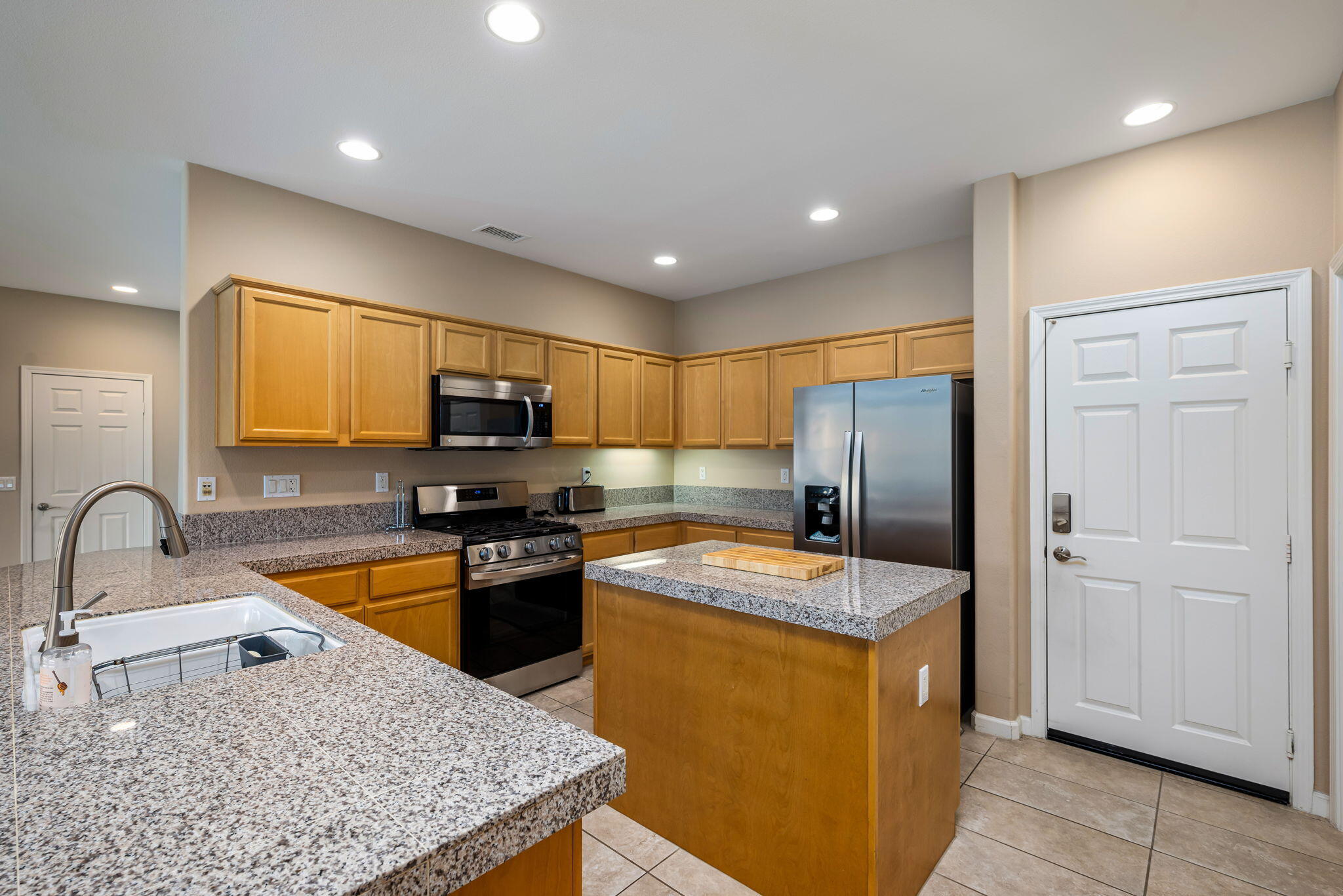 60237 Angora Court La Quinta, CA 92253 - Photo 13 of 75 a kitchen with stainless steel appliances granite countertop a sink stove and refrigerator
