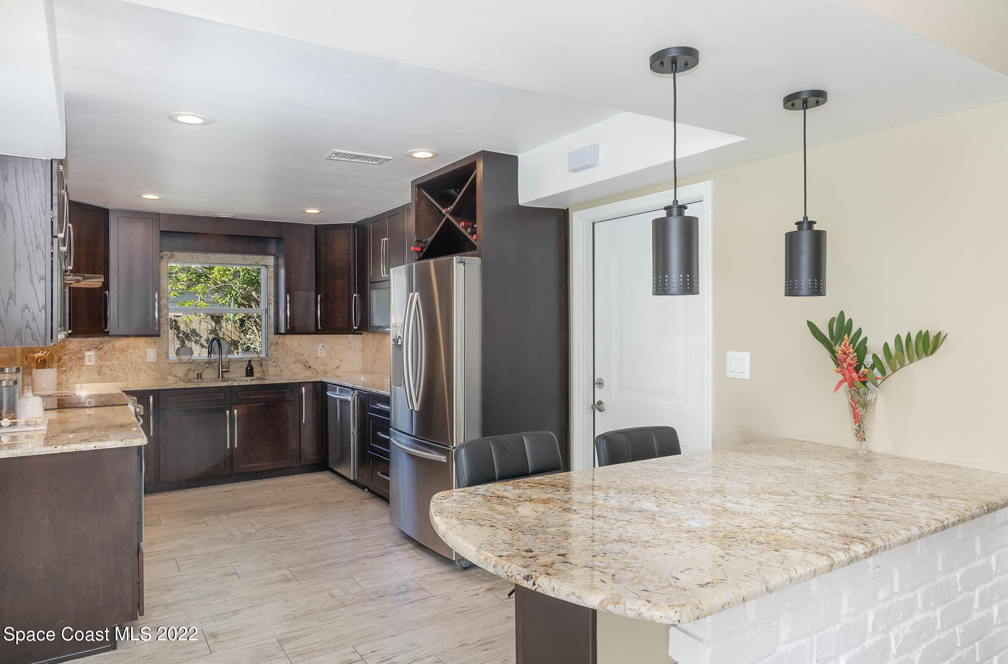 947 Santa Cruz Road Cocoa Beach, FL 32931 - Photo 13 of 29 a kitchen with stainless steel appliances kitchen island granite countertop a refrigerator a sink a stove and dishwasher