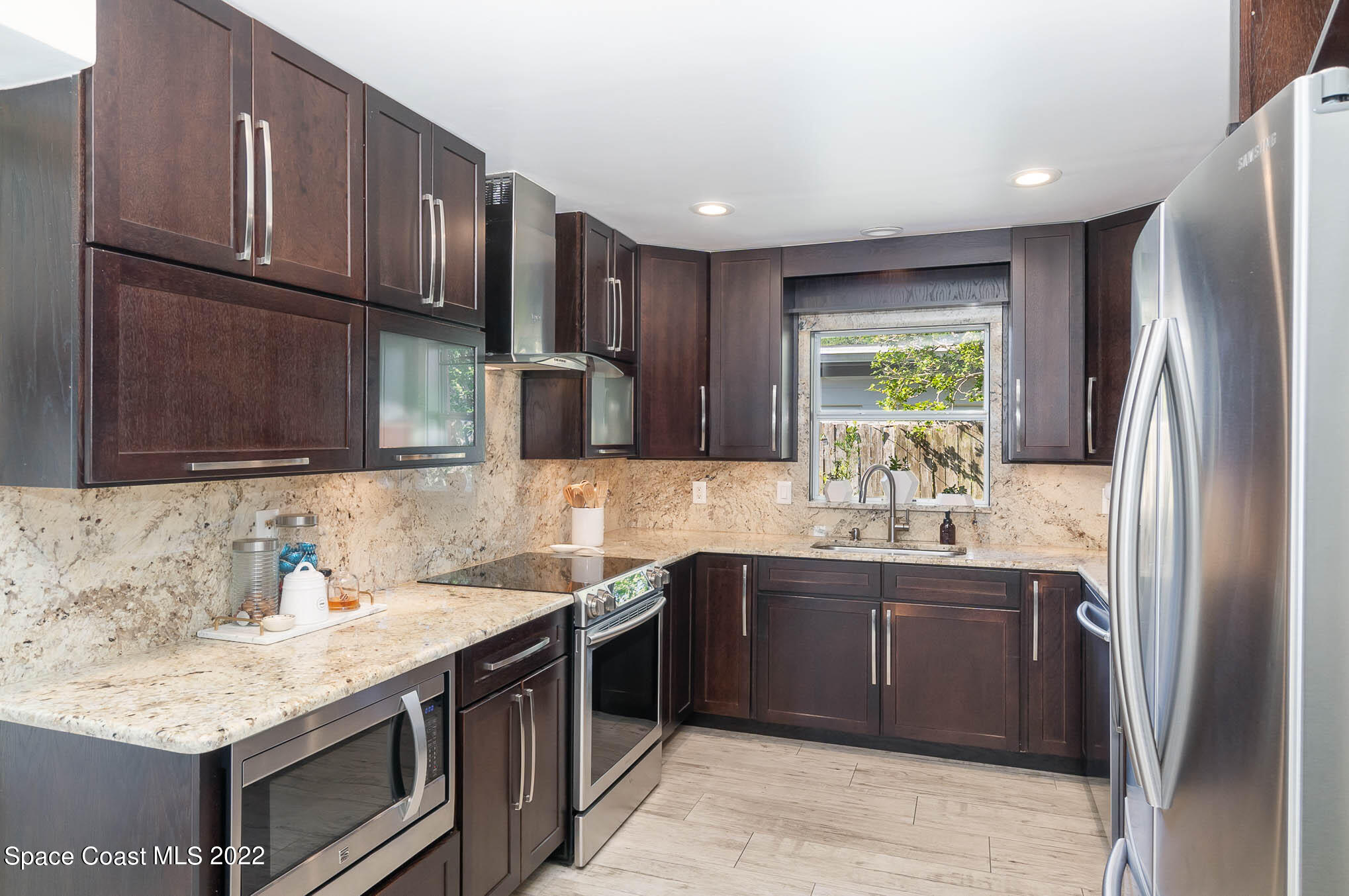 947 Santa Cruz Road Cocoa Beach, FL 32931 - Photo 14 of 29 a kitchen with stainless steel appliances granite countertop a sink stove and refrigerator