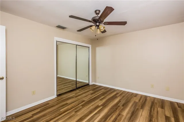 a view of a room with wooden floor and a ceiling fan