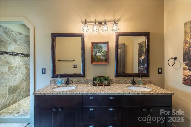 a bathroom with a granite countertop sink a mirror and a shower