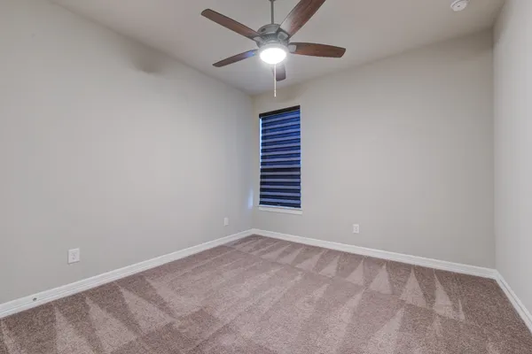 a view of a room with a ceiling fan and a window