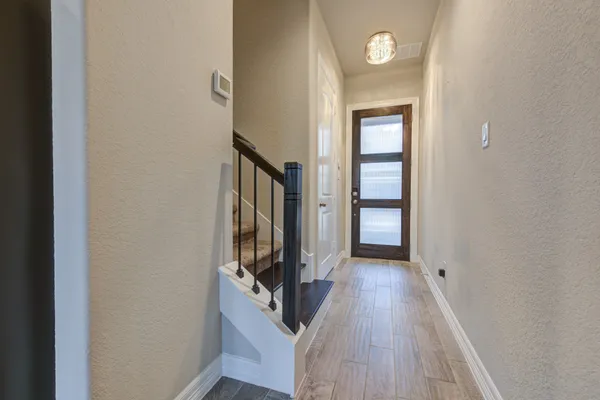 a view of a hallway with wooden floor and a living room