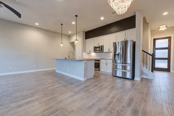 a view of kitchen with stainless steel appliances a refrigerator and wooden floor