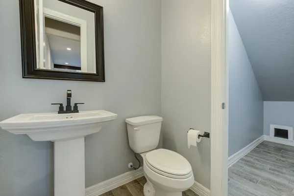 a bathroom with a toilet a sink and mirror