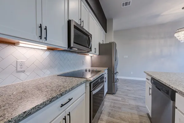 a kitchen with stainless steel appliances granite countertop a sink stove and microwave