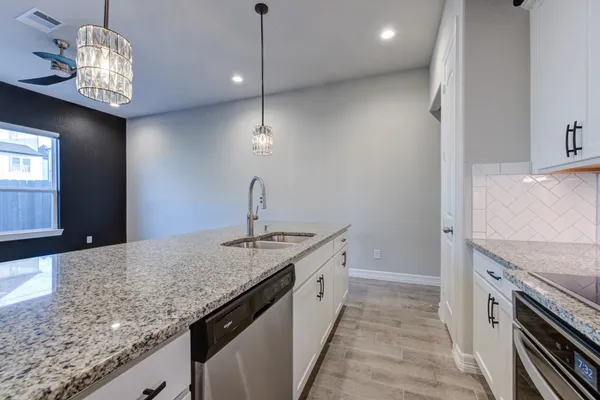 a kitchen with stainless steel appliances granite countertop a sink and a stove