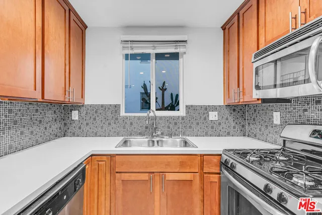 a kitchen with stainless steel appliances granite countertop a sink stove and cabinets