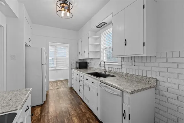 a kitchen with granite countertop a sink stove and cabinets