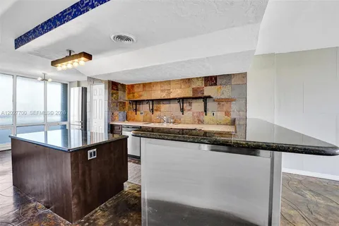 a kitchen with granite countertop a sink and a stove