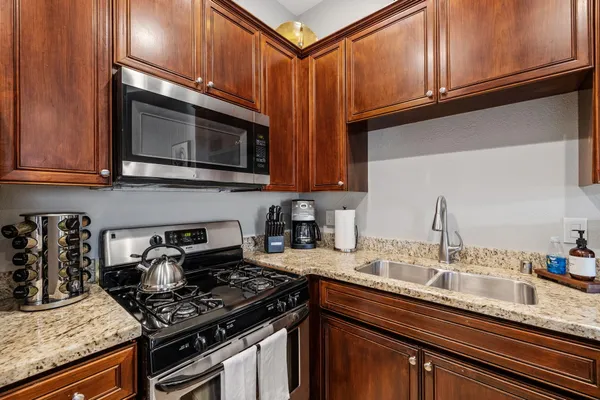 a kitchen with stainless steel appliances granite countertop a stove microwave and sink