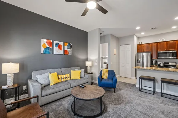 a living room with furniture a rug and white walls