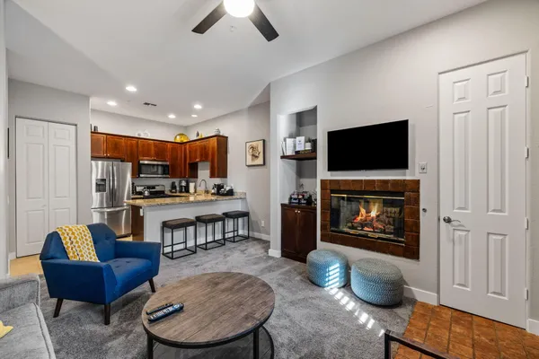 a living room with furniture a flat screen tv and kitchen view