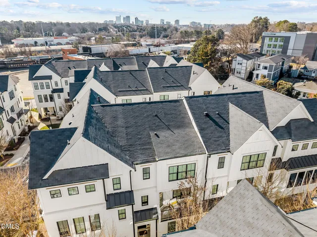 an aerial view of multiple houses with a yard