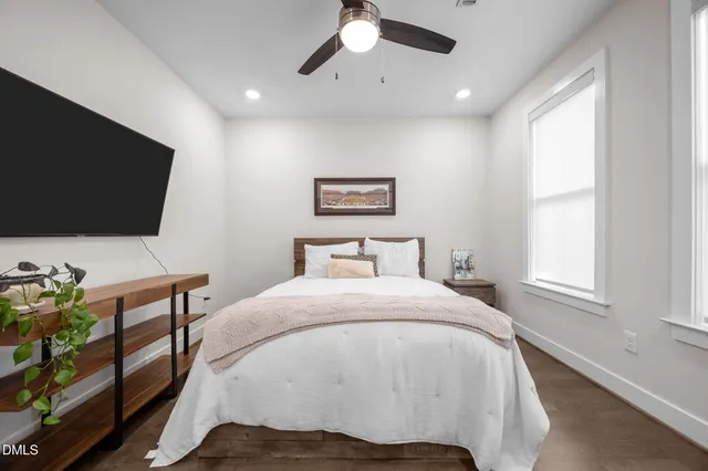 a bedroom with a bed window and a flat screen tv