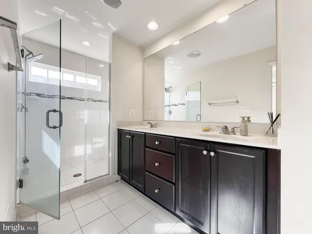 a bathroom with a double vanity sink mirror and shower