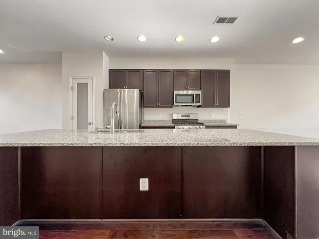 a view of kitchen with stainless steel appliances granite countertop a sink
