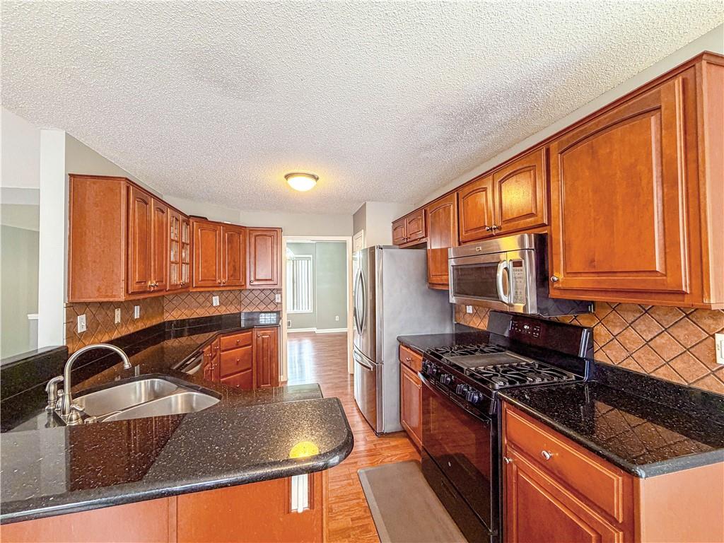 2950 Mandy Court Jonesboro, GA 30236 - Photo 11 of 40 a kitchen with stainless steel appliances granite countertop a sink stove and refrigerator