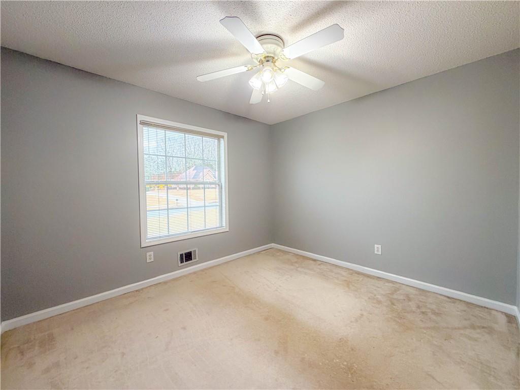2950 Mandy Court Jonesboro, GA 30236 - Photo 14 of 40 en empty room with windows and chandelier fan