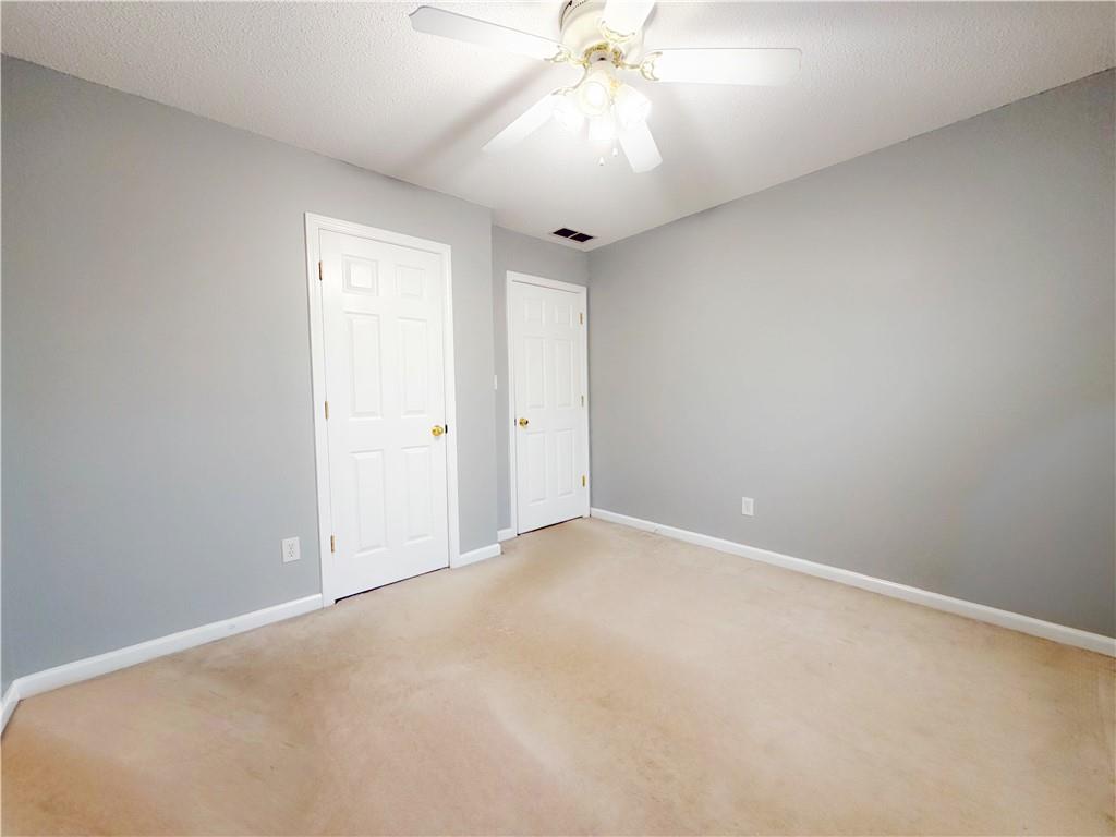 2950 Mandy Court Jonesboro, GA 30236 - Photo 15 of 40 an empty room with a chandelier fan and windows