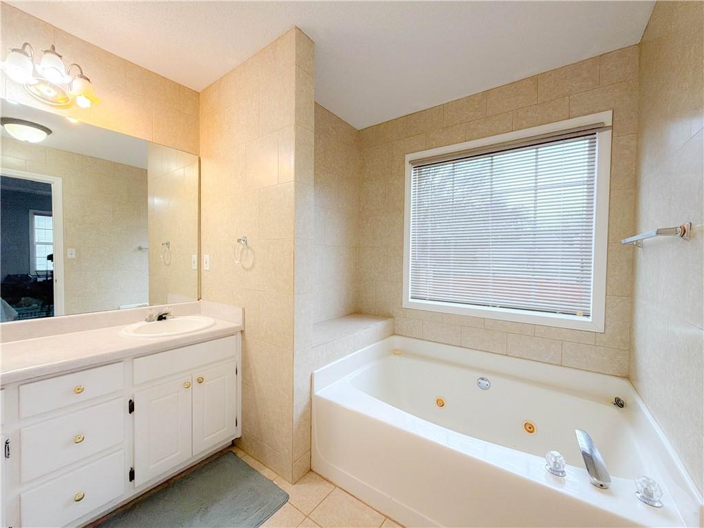 2950 Mandy Court Jonesboro, GA 30236 - Photo 21 of 40 a bathroom with a tub a sink a window and a mirror