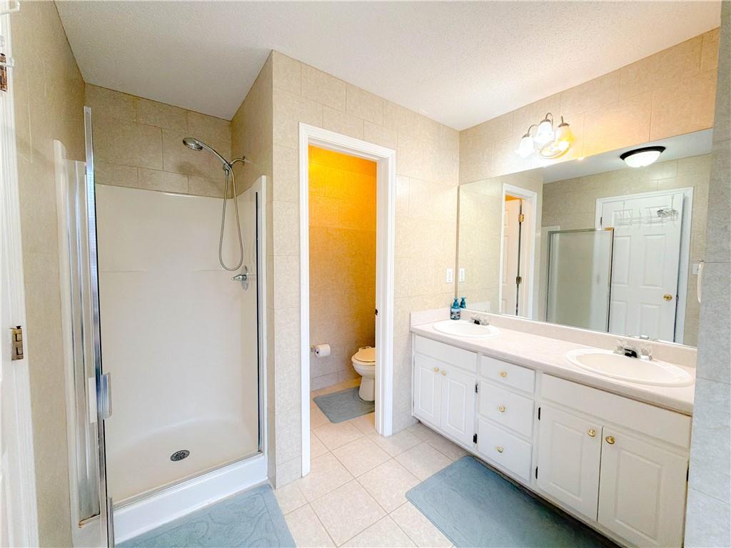 2950 Mandy Court Jonesboro, GA 30236 - Photo 22 of 40 a spacious bathroom with a double vanity sink toilet mirror and windows