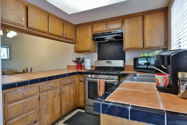 a kitchen with stainless steel appliances granite countertop a stove and cabinets
